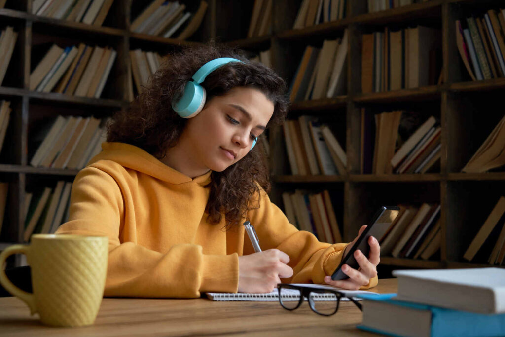 girl wearing headphones doing homework