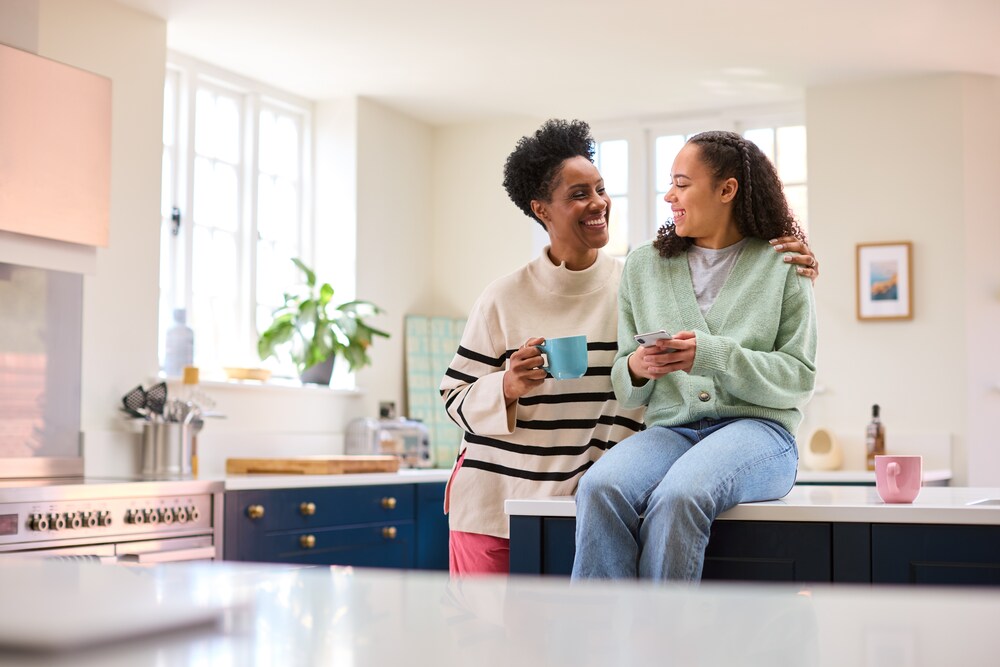 Mom and daughter laughing in the kitchen