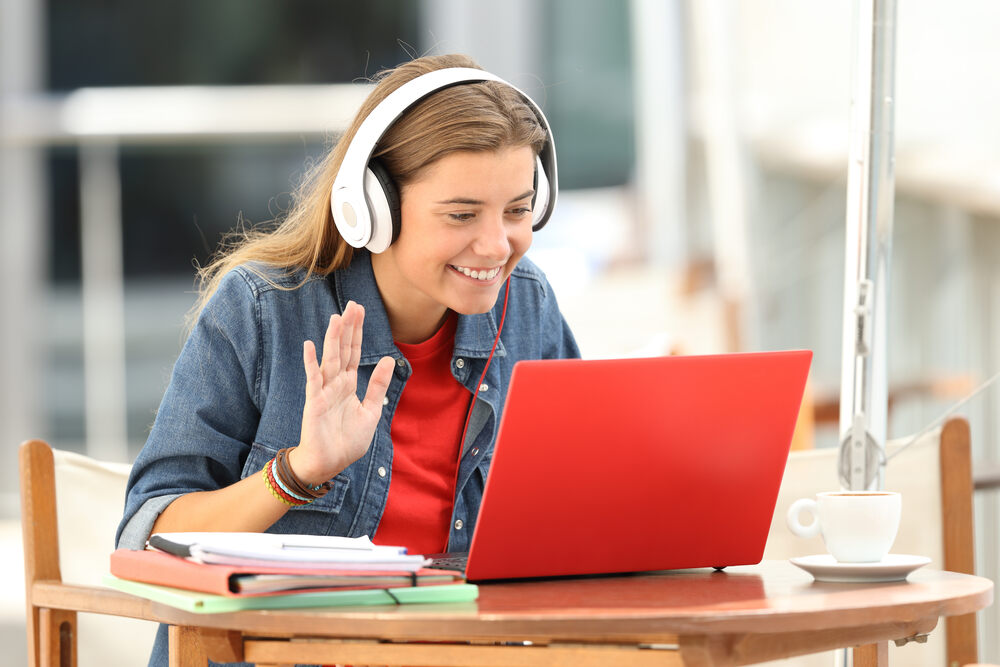 Girl smiling at a laptop with headphones on 