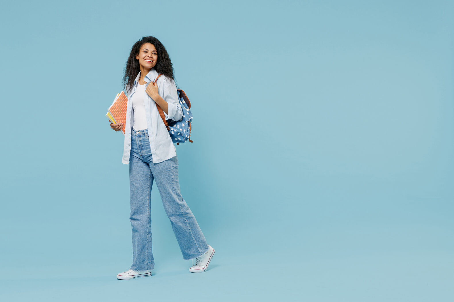 girl holding backpack on a blue background