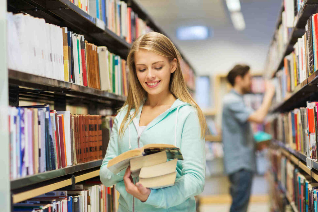 teen girl choosing books at the library